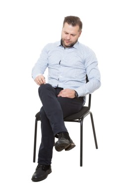man sitting on chair. Isolated white background. Body language. picking nonexistent lint
